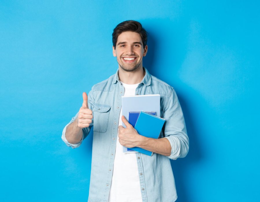 young-man-student-with-notebooks-showing-thumb-up-approval-smiling-satisfied-blue-studio-background (1) young-man-student-with-notebooks-showing-thumb-up-approval-smiling-satisfied-blue-studio-background (1)