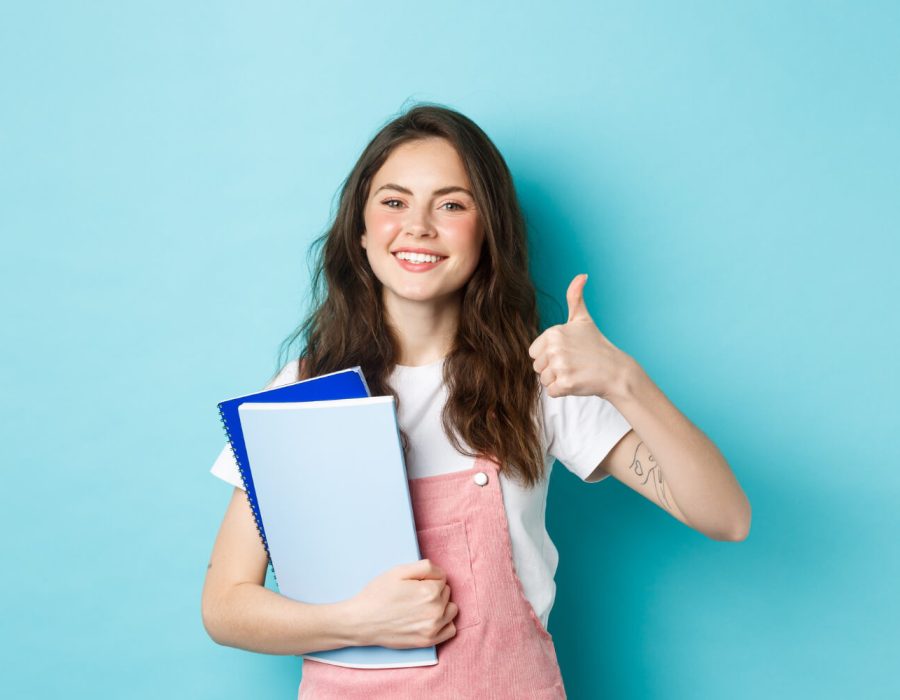 young-woman-attend-courses-girl-student-studying-holding-notebooks-showing-thumb-up-approval-recommending-company-standing-blue-background (1) young-woman-attend-courses-girl-student-studying-holding-notebooks-showing-thumb-up-approval-recommending-company-standing-blue-background (1)